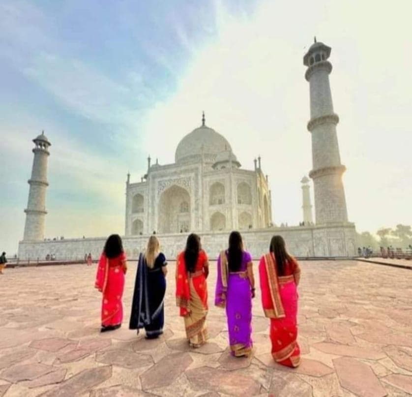 A group of guests in saris walking together at the monument